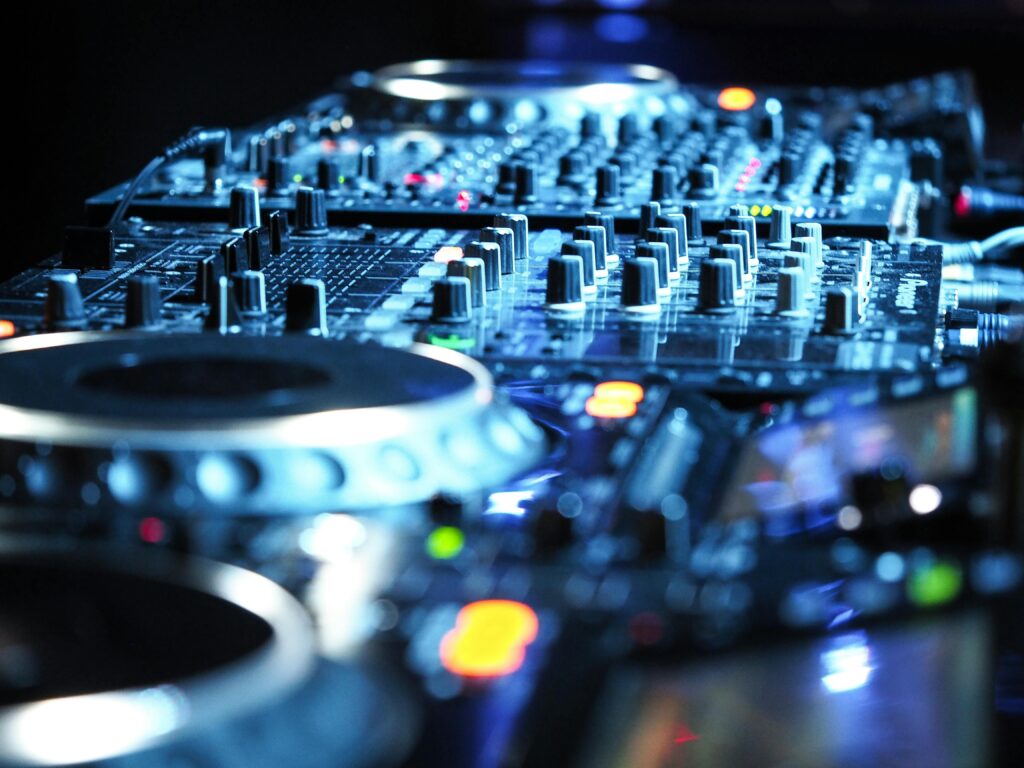 Close-up view of DJ equipment featuring an audio mixer and control knobs, ideal for nightlife and music themes.